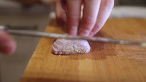 Slicing-onion-with-sharp-knife-on-a-cut-board