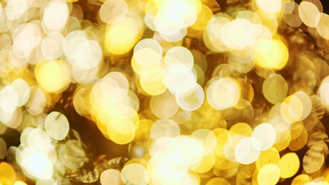 Warm blurred sparkle from holiday tree ornaments captured in artistic light play