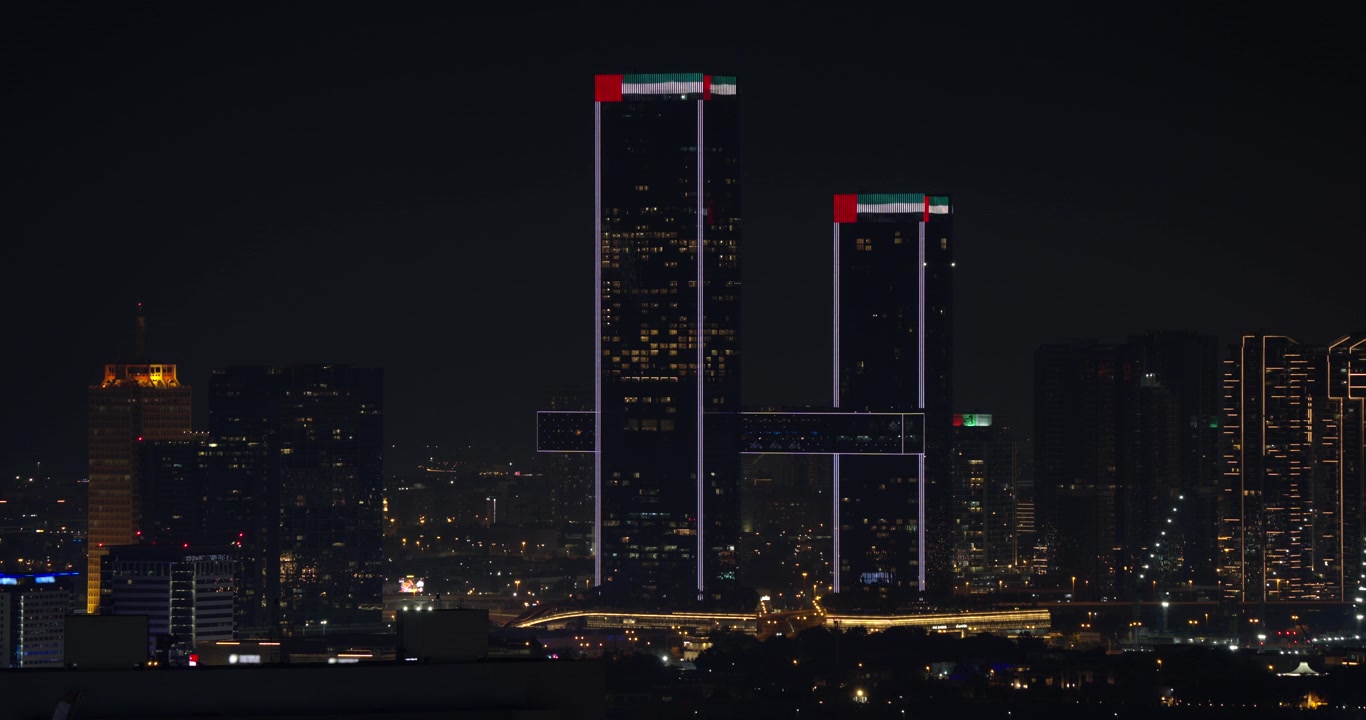 Arranha-céus Iluminados com Projeção da Bandeira dos Emirados Árabes Unidos à Noite