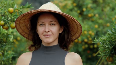 woman in a straw hat in an orange orchard