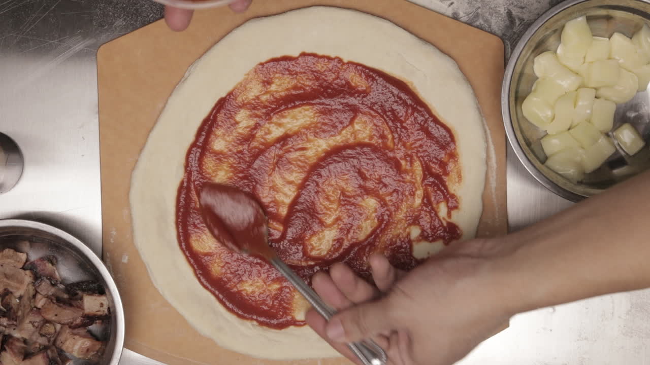 Stendere salsa densa e ricca sull'impasto della pizza