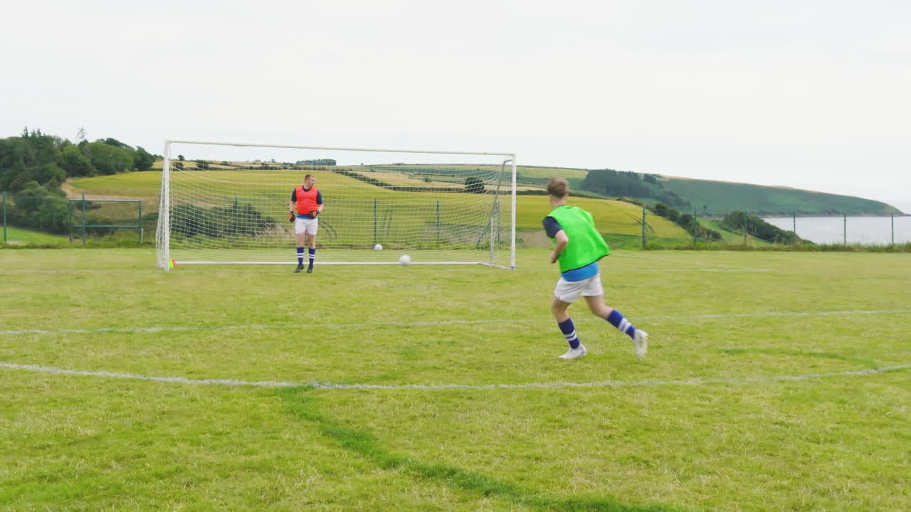 Male and female soccer players, one player shooting at goal and scores point on pitch