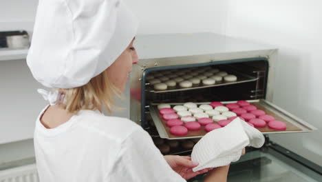 woman chef preparing macarons in oven