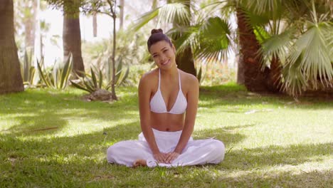 joven meditando en un jardín tropical