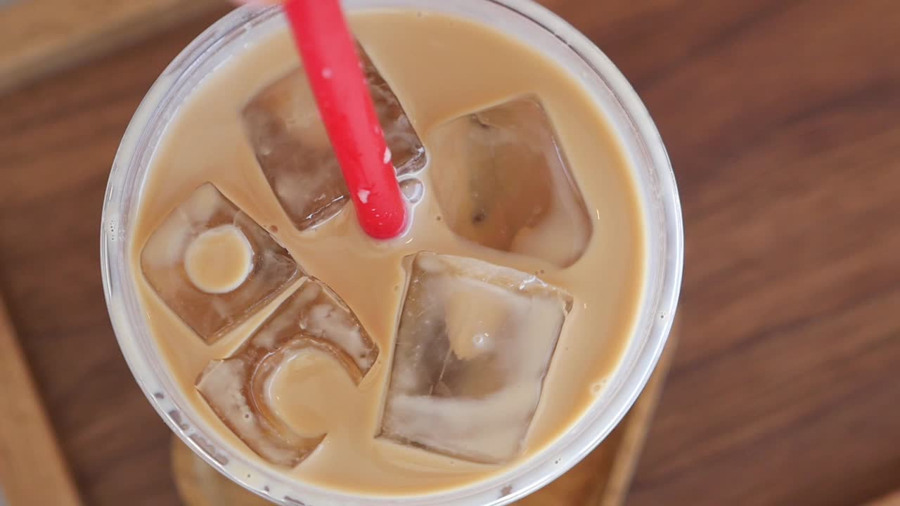 Café helado en un vaso de plástico con una pajita roja