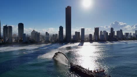 drone captures sand dredging near gold coast skyline at sunset, highlighting coastal erosion and urban landscape