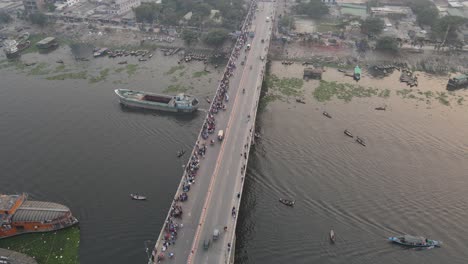 aerial view of traffic on a bridge at old dhaka steamer ghat with cars and ships crossing along buriganga river in dhaka, bangladesh