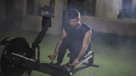 Der-Hübsche-Sportler-Trainiert-Im-Fitnessstudio-Mit-Einem-Rudergerät