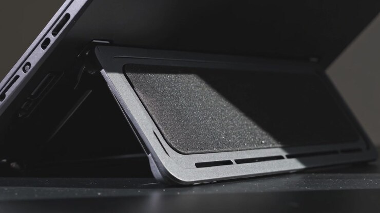 Luce direzionale che si sposta evidenziando le porte della cerniera con bordo metallico su un tablet appoggiato con custodia a libro sulla scrivania