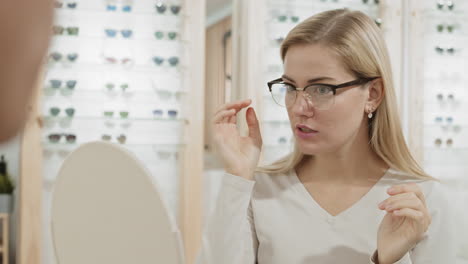 woman trying on glasses in optical shop