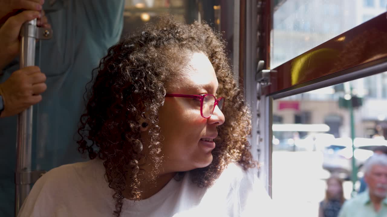 Mixed raced woman is riding a train car during a bright sunny afternoon in Nola