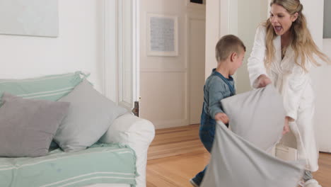 Feliz-Madre-E-Hijo-Juegan-A-Atrapar-Corriendo-Por-La-Casa-Mamá-Jugando-Pelea-De-Almohadas-Con-Un-Niño-Pequeño-Disfrutando-Juntos-De-Un-Divertido-Fin-De-Semana-Imágenes-De-4k