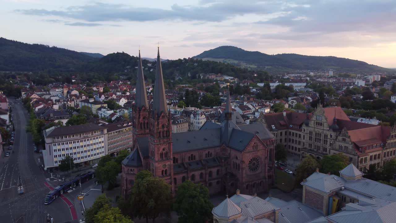 Aerial view of catholic church Johanneskirche in gothic old town of Freiburg im Breisgau during sunset, Germany