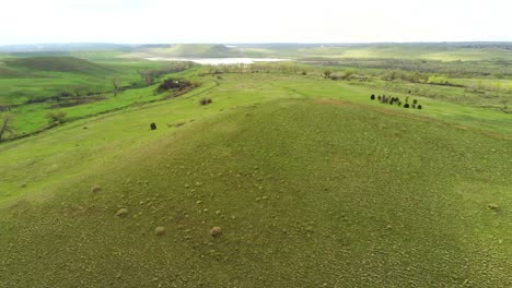 a drone pan across a plush green valley on a hazy morning