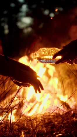 sharing water by the campfire at night