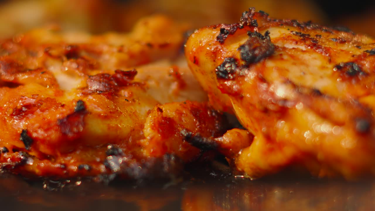 Macro Close Up of Marinated BBQ Chicken Thighs on Flat Griddle with Juices Bubbling from Below. Delicious Tasty Poultry Food