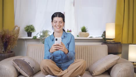 Young-woman-laughing-at-phone-message.