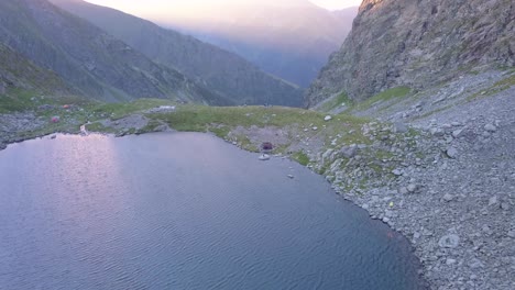 Peaceful-mountain-like-at-high-altitude-with-colors-of-sunset-reflecting-on-calm-surface-of-the-water