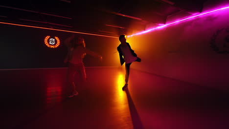 couple dancing in a neon lit dance studio