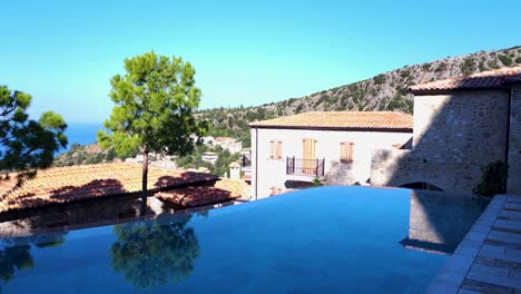 piscina infinita, veranda con vista al mar, pueblo mediterráneo, y una impresionante arquitectura de piedra - un complejo de lujo experiencia elegancia costera