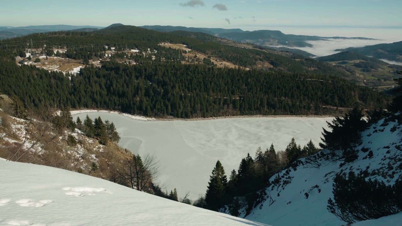 Pohled na francouzské jezero z Vogéz pokryté ledem.