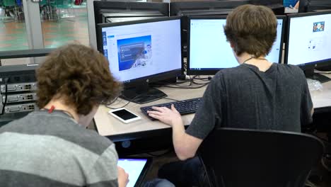 students working together at a computer in cyber security class