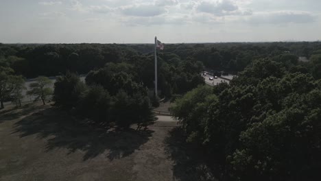 An-aerial-view-of-a-park-next-to-a-highway-on-a-sunny-day-with-clouds