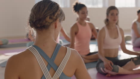 yoga class of beautiful women practice seated side bend pose enjoying healthy lifestyle exercising in fitness studio instructor teaching group meditation at sunrise