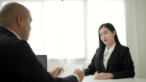 smart asian woman shakes hands to greet a hr staff before a job interview to apply for a job. happy woman seeker or insurance broker presenting a business deal. business woman sending resume.