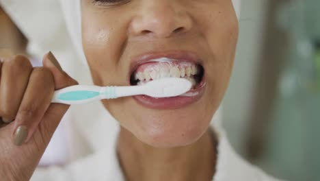 Close-up-of-mixed-race-woman-brushing-teeth