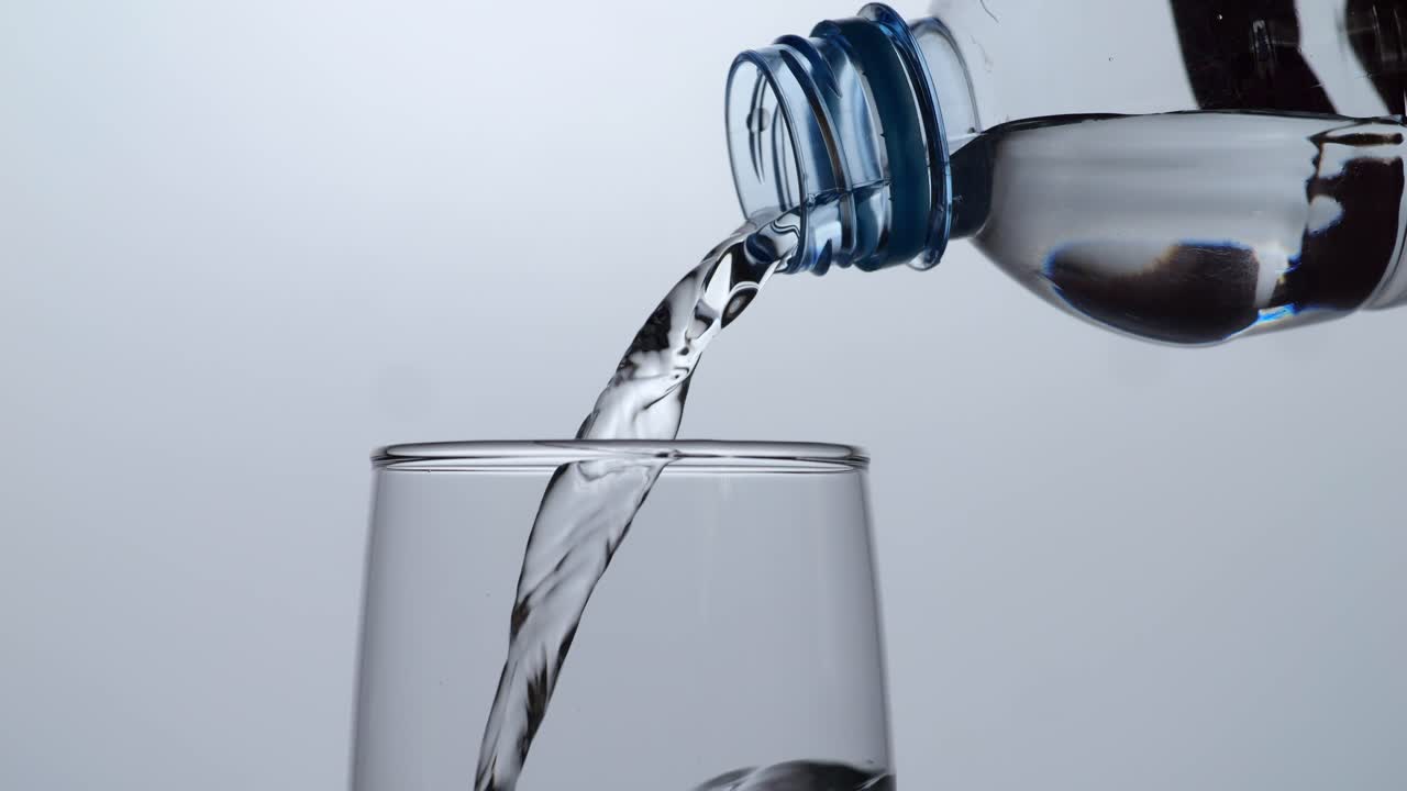 플라스틱 병에서 유리병으로 물을 부어 넣는 것