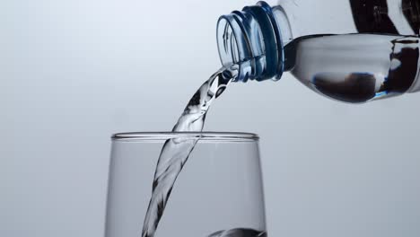 verter agua de una botella de plástico en un vaso