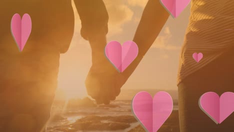 animation of heart icons over caucasian couple holding hands