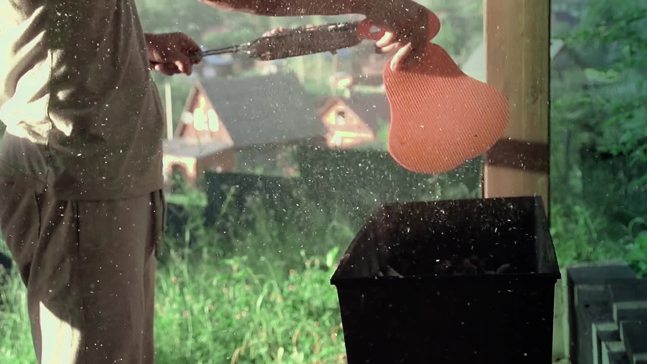 el joven sopla los carbones en el brasero