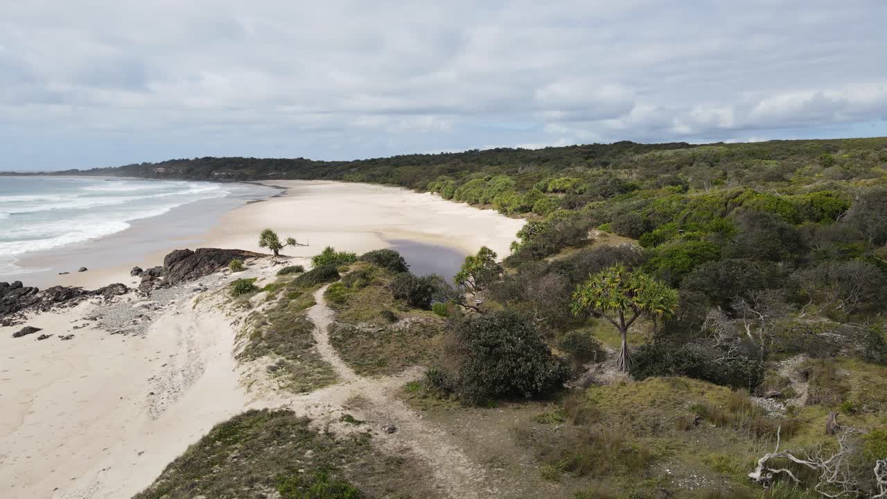 Percorrendo un sentiero costiero che conduce a una pozza d'acqua nascosta vicino a una spiaggia oceanica