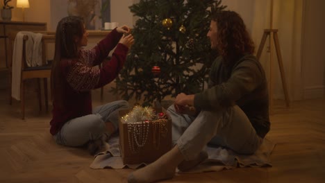 pareja decorando el árbol de navidad