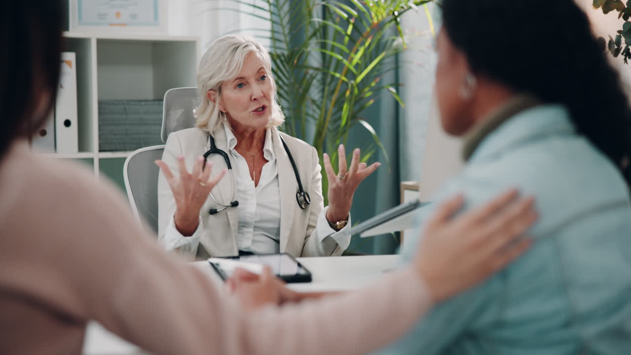 una doctora habla con sus pacientes en el consultorio de un médico