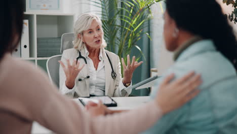 a doctor talks to her patients in a doctor's office