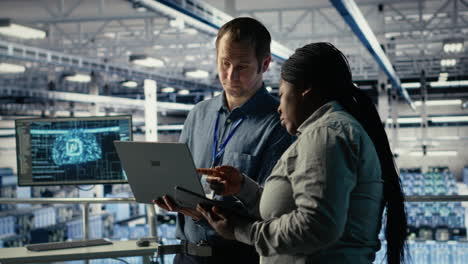 team of data center programmers monitoring deep learning processes with laptop