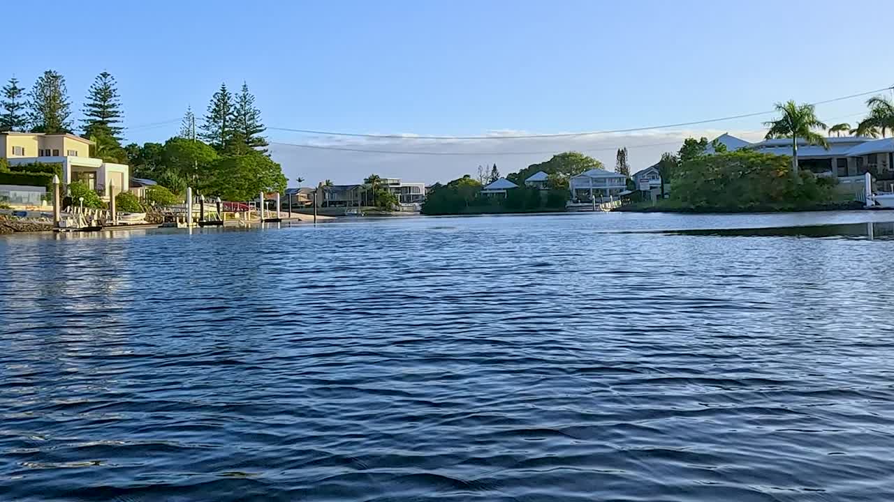 Enjoy serene views of riverside homes and calm waters under a clear blue sky.