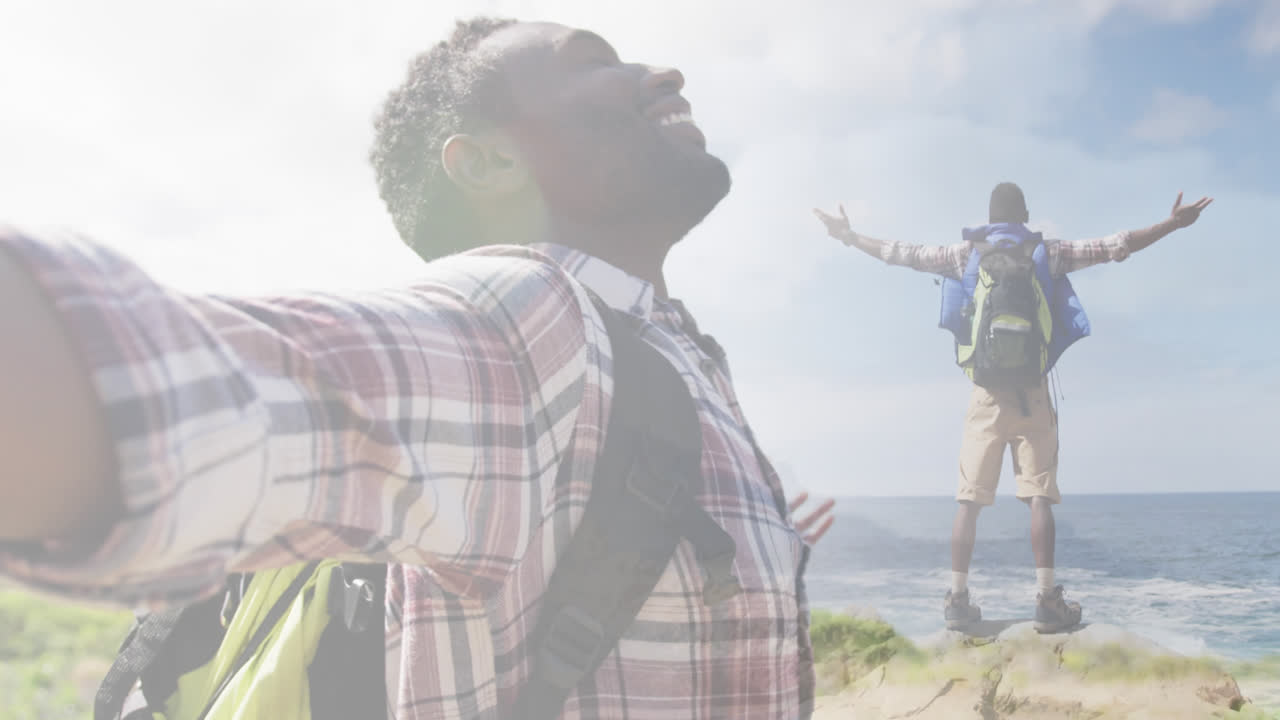 compuesto de un hombre afroamericano sonriente caminando por la ladera de la montaña, de pie con el cuerpo extendido