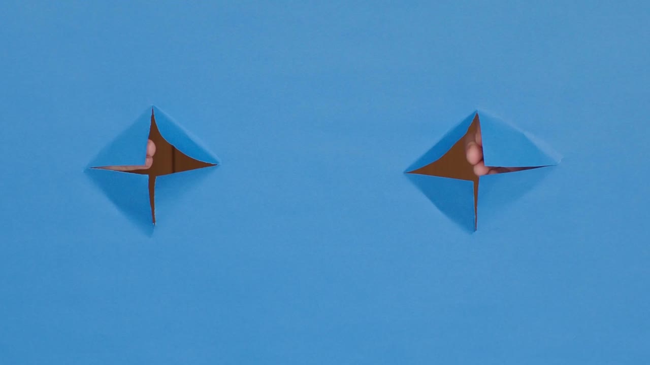 manos de saludo a través de agujeros, sobre un fondo azul