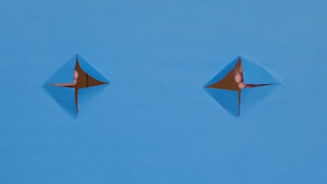 greeting hands through holes, on a blue background