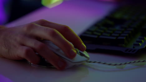 Closeup-neon-hand-clicking-esport-mouse.-Cyber-player-enjoying-gaming-weekend