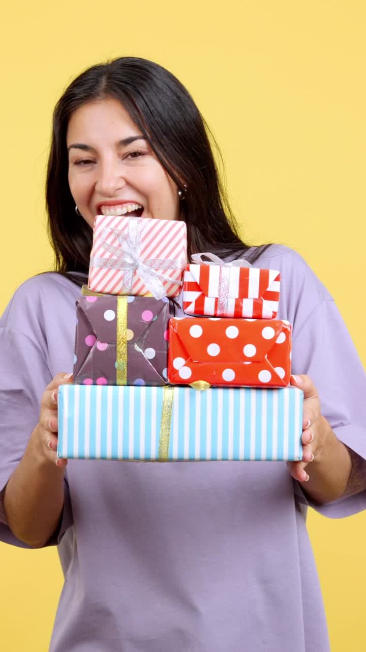 Happy Woman Holding a Stack of Colorful Gifts