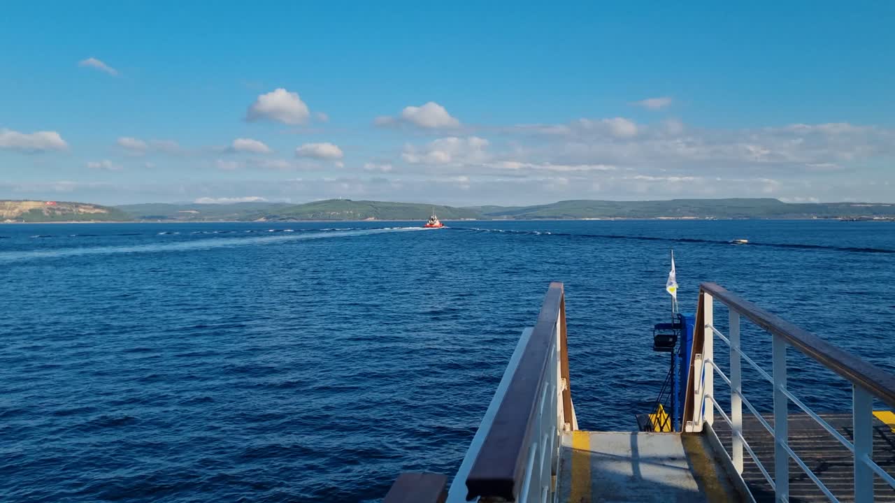 View from a moving ferry crossing the Dardanelles Strait (Çanakkale Boğazı) in northwestern Turkey, with deep blue water glistening under a clear sky