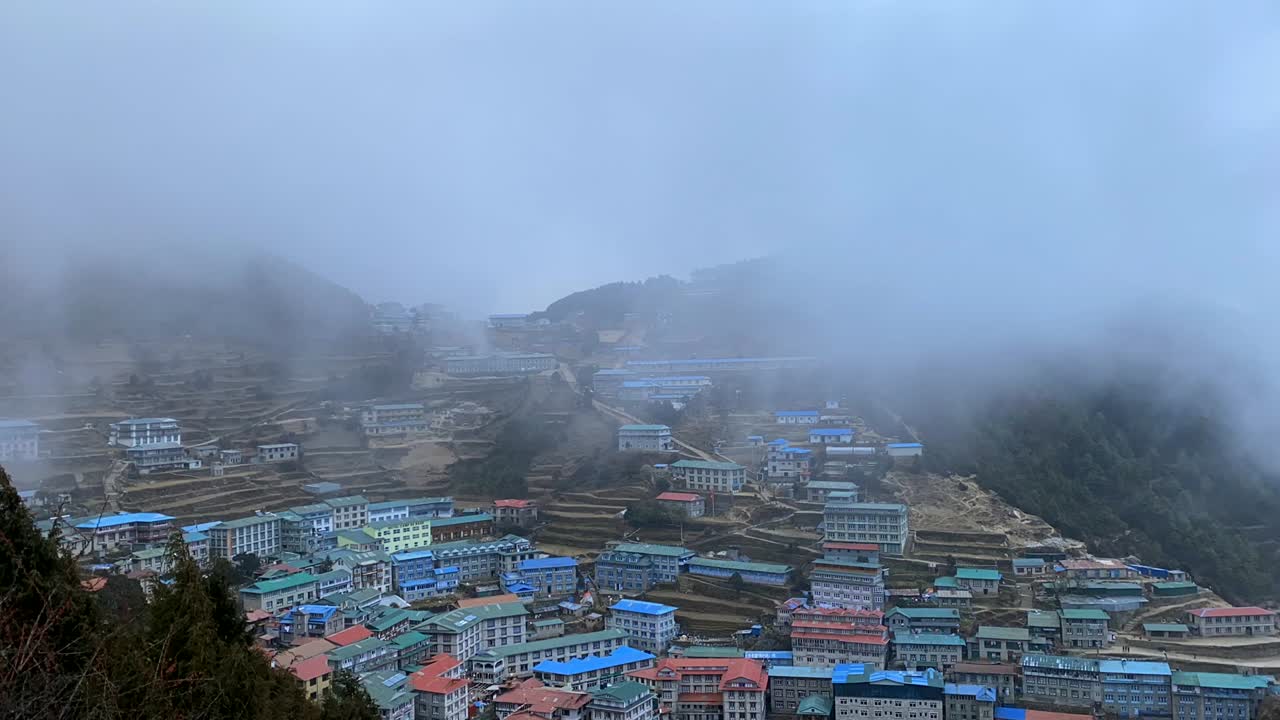 una vista de ángulo alto de namche bazar con un lapso de tiempo de nubes rodando sobre la ciudad y las cordilleras