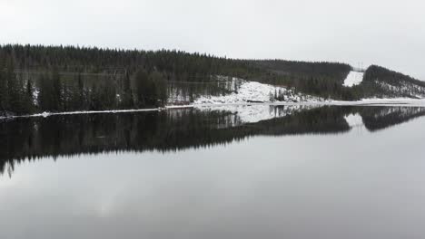 aerial shot of a partially frozen lake or reservoir in the middle of sweden during the midwinter solstice