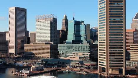 rising aerial reveals baltimore business district skyline located on inner harbor, marina and tourist area