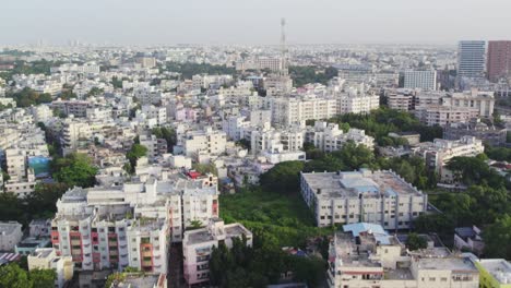 cinematic aerial footage of a indian city showing huge antenna tower and buildings closely